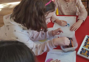 Dzieci malują pastelami kolorową walentynkę.